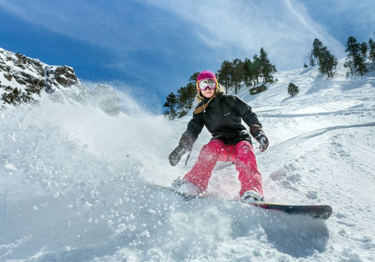 Девушка катается на сноуборде в горах