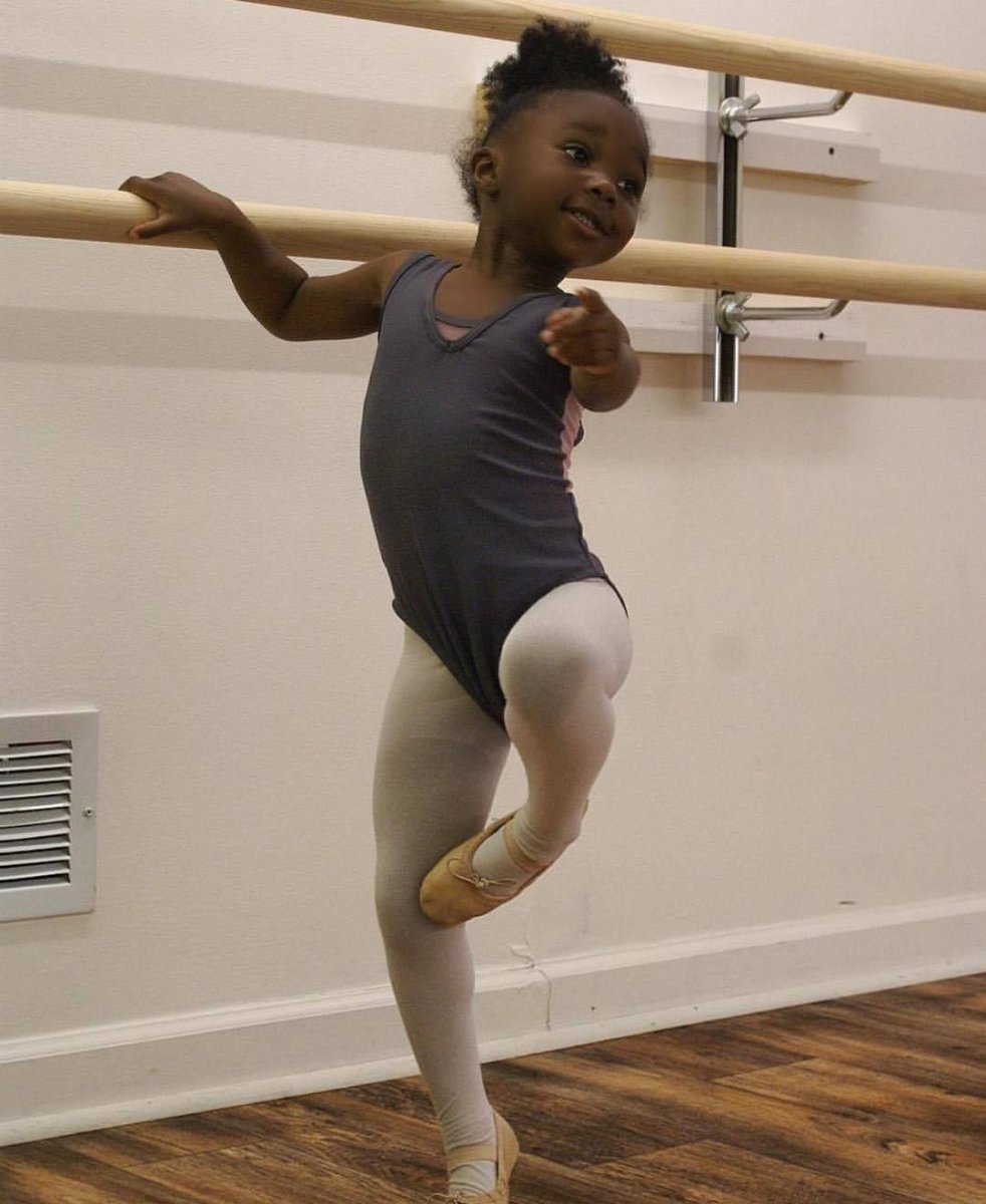 Маленькая темнокожая девочка танцует