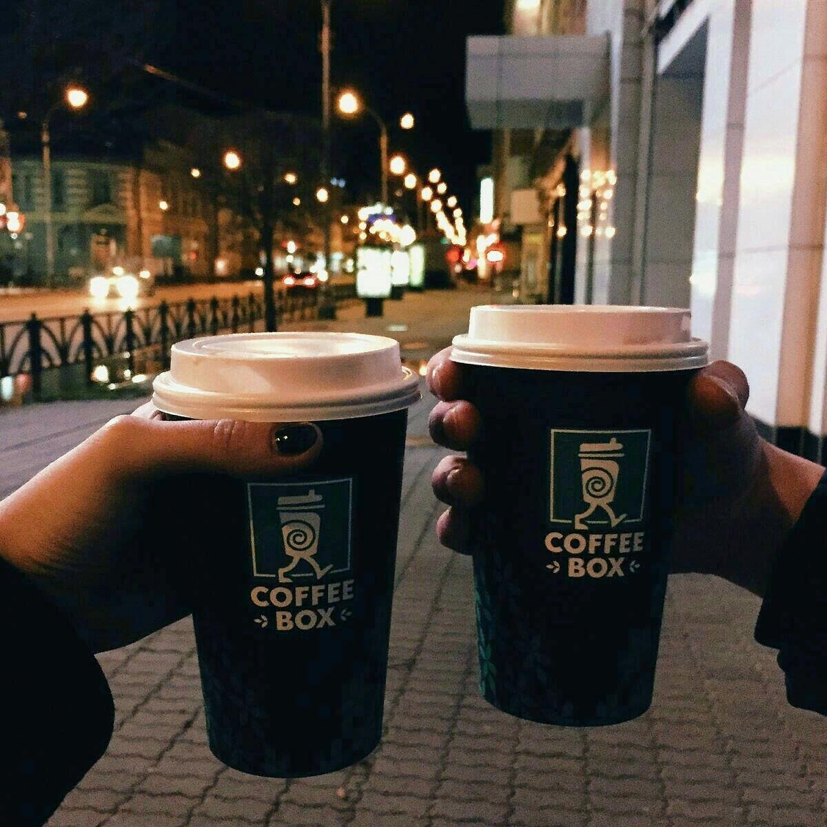Стакан кофе в руках на улице