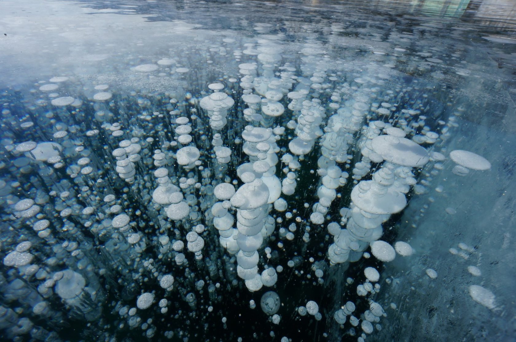 Пузырьки на байкале. Метановые пузырьки на Байкале. Метановые пузыри во льду Байкала. Метановые пузыри на Байкале. Замерзшие пузыри метана в Байкале..