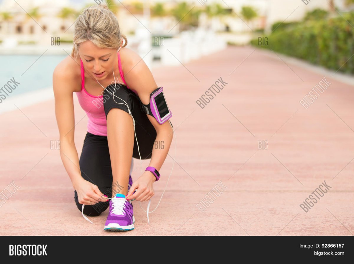 Бегущая женщина с фитнес браслетом