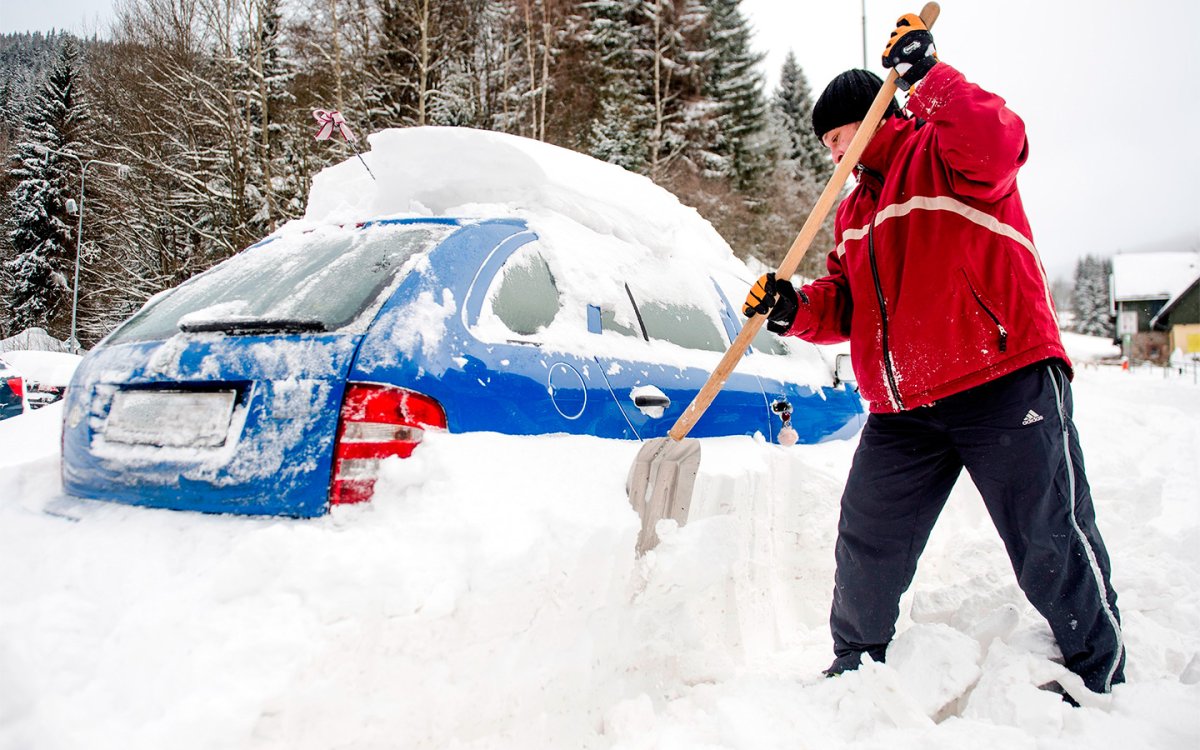 Раскапывать машину из снега