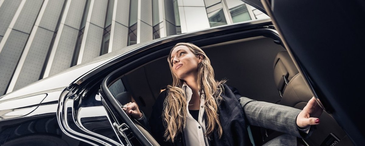Успешная деловая женщина с телефоном в машине