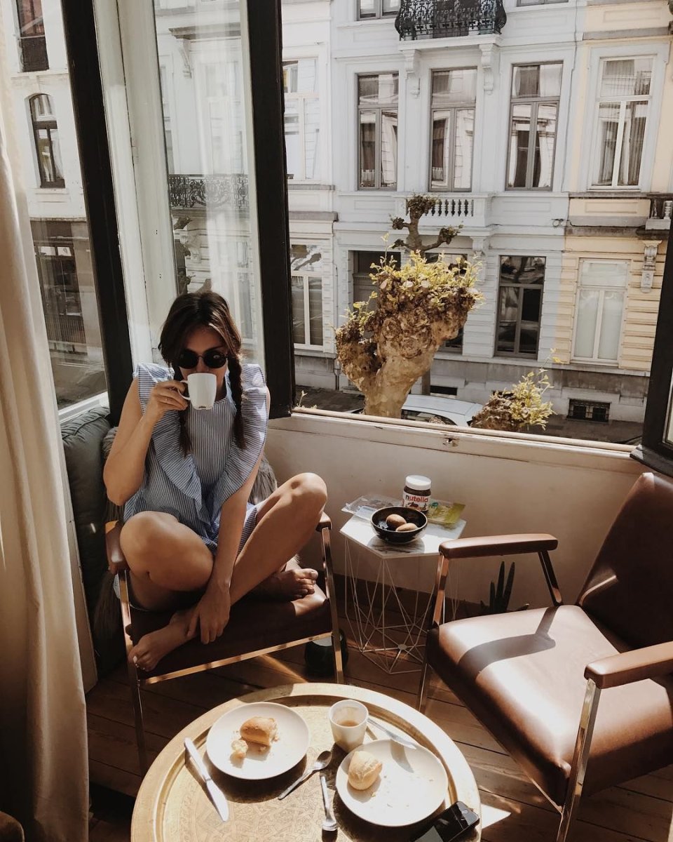 Девушка пьет кофе на балконе